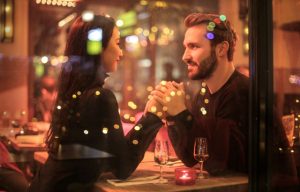 healthy loving couple holding hands under romantic lights